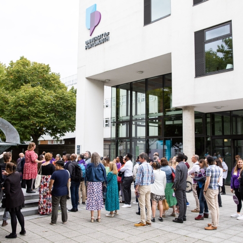 Photo of attendees gathered outside the Dennis Sciama CafeAlumni Weekend