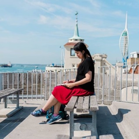 Student reading outside on a sunny day at the Hotwalls