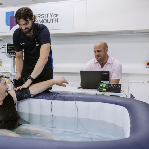 A study participant in a hot tub having her blood pressure checked 