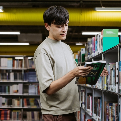 Student reading a book in the University Library 