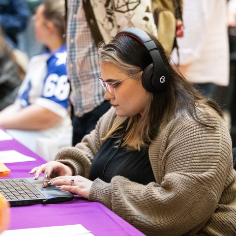 Woman with headphones using a laptop