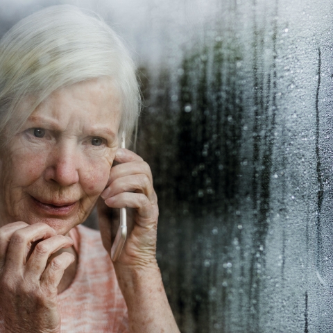 Elderly woman on the phone at a window
