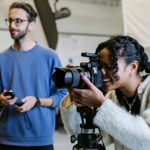 Woman using a DSLR camera in a photo studio with man