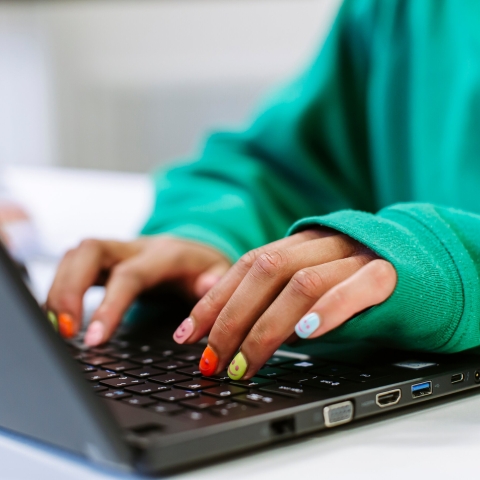 Hands typing on laptop