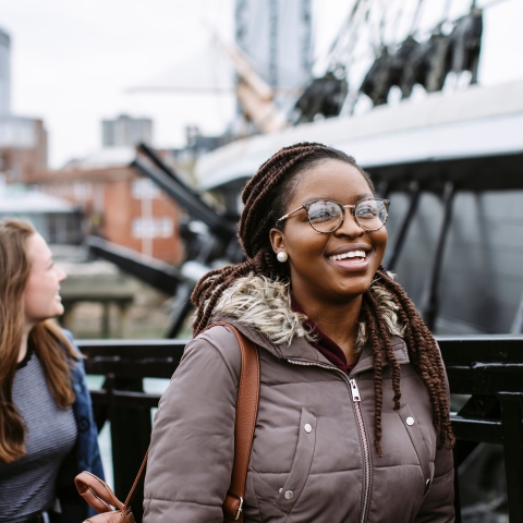 Female student smiling while passing by harbour