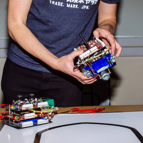 Electronic engineering student holding project