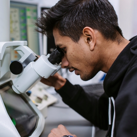 A student looking into a microscope