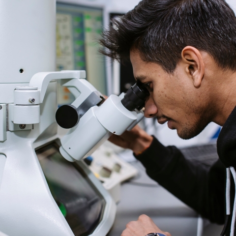 A student looking into a microscope
