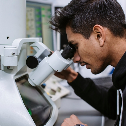 A student looking into a microscope