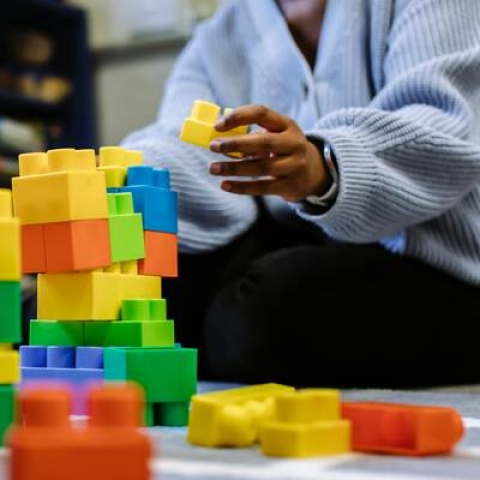 Person building a tower with plastic blocks 