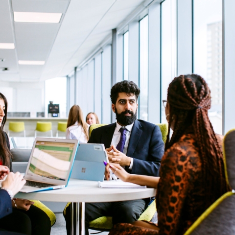 Four people sat round a table in a meeting