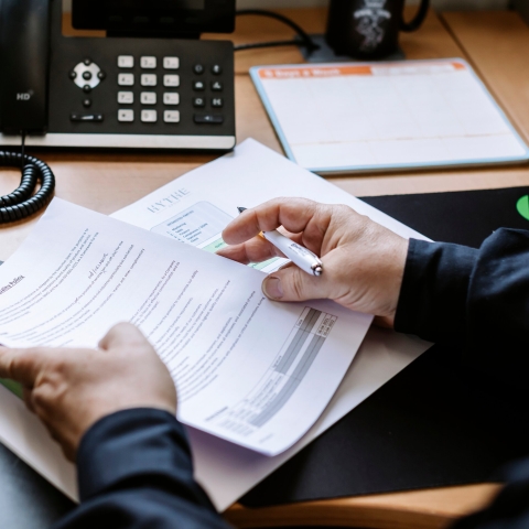 Hands holding paper at a desk