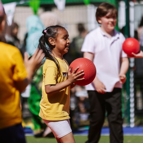 A little girl holding a basketball