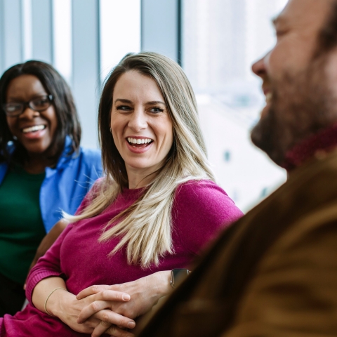 Three students smiling and chatting in learning space
