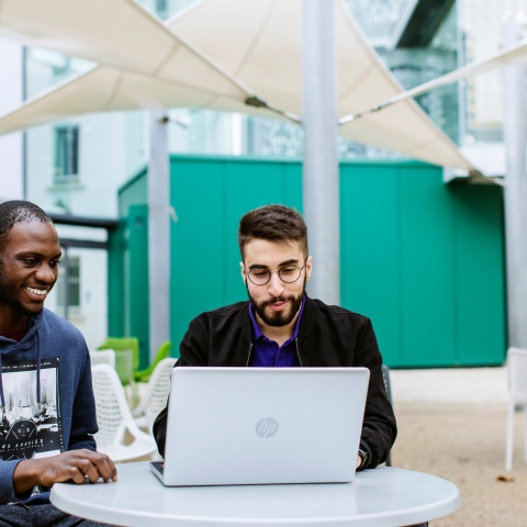 Students looking at a laptop outside Portland building