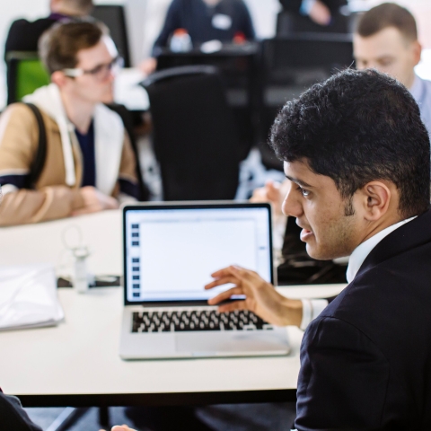 Man working with a colleague at a laptop