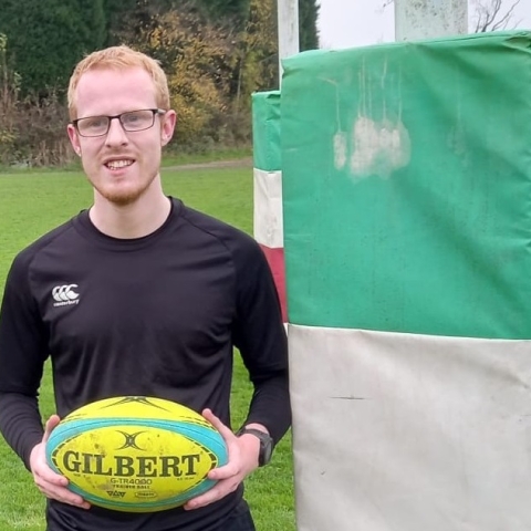 Andrew Fleet posing with a rugby ball