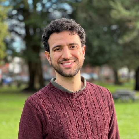 Global Recruitment officer Guiliano looking at the camera with trees in the background