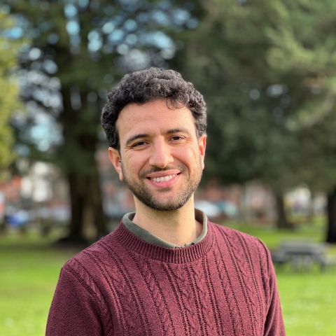 Global Recruitment officer Guiliano looking at the camera with trees in the background