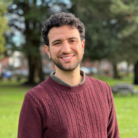 Global Recruitment officer Guiliano looking at the camera with trees in the background
