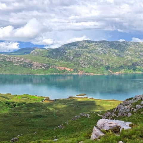 Image capturing a nature landscape with mountains, grass and a lake 