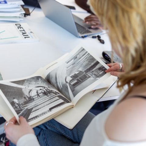 An MA Architecture student looking at historic photographs in a book
