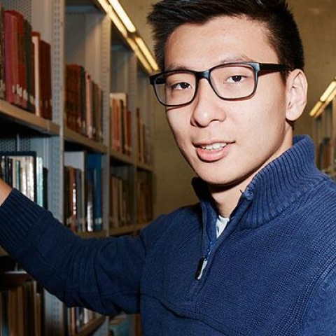 Creative writing student between bookshelves