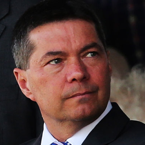 Mark Catlin looking to the side wearing suit in a photograph
