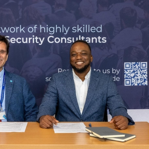 Dennis Roe and Dr John Akerele sat at desk with papers
