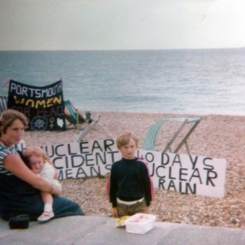 Picture of woman and children on beach in front of banners