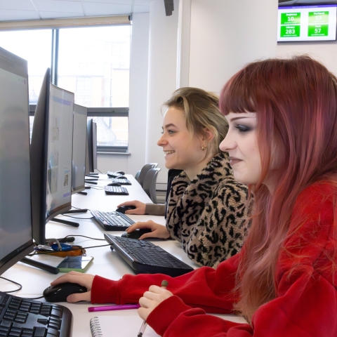 Two people working at computers. 