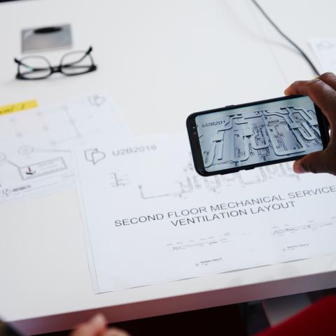 Hand-held mobile device displays augmented reality image of building plan