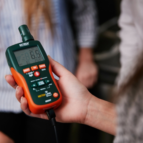 Close up of hand holding moisture meter