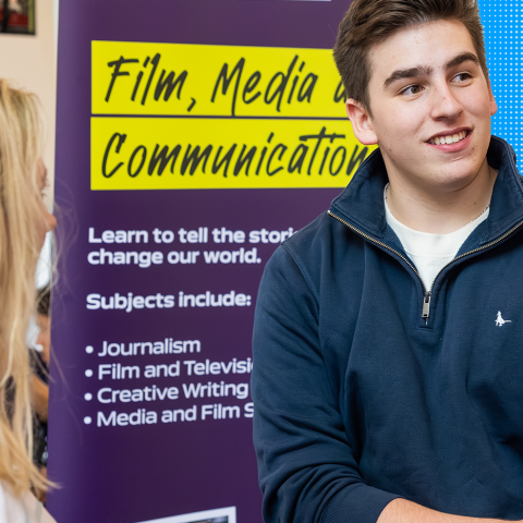 Student siting smiling infront of another person