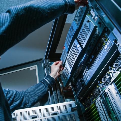 Information systems student reaches into server