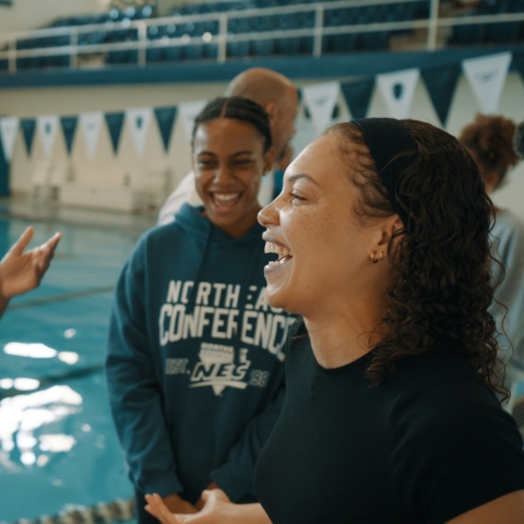 Seren Jones at a swimming pool laughing with fellow swimmers