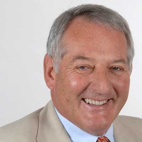 Sir Jonathan Band smiling to camera in headshot