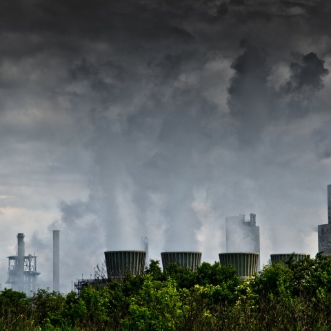 Pollution from factory rising into a dark grey sky