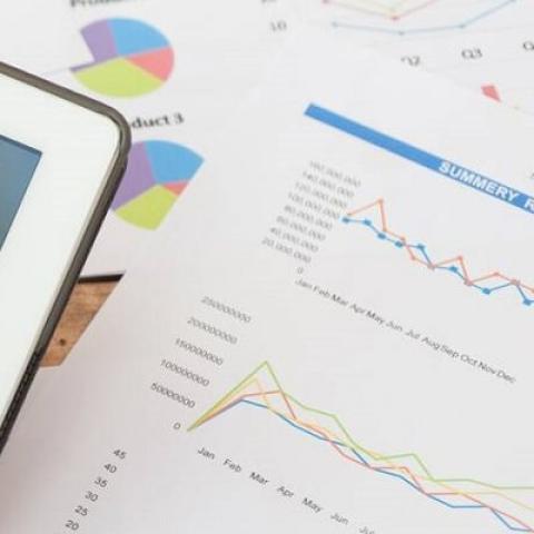 Data analytics student holds tablet with infographics