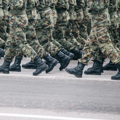 Soldiers dressed in army camouflage march in formation