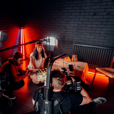 A film crew on set liaising with an actor