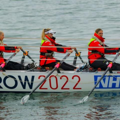 team of scientists rowing a rowboat for GB Row Race