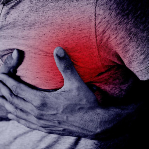 A man holding his heart tightly as if in pain