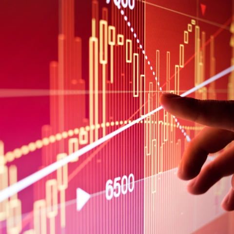 A hand gesturing to data on a screen