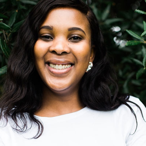 Student smiling with arms crossed in Ravelin Park