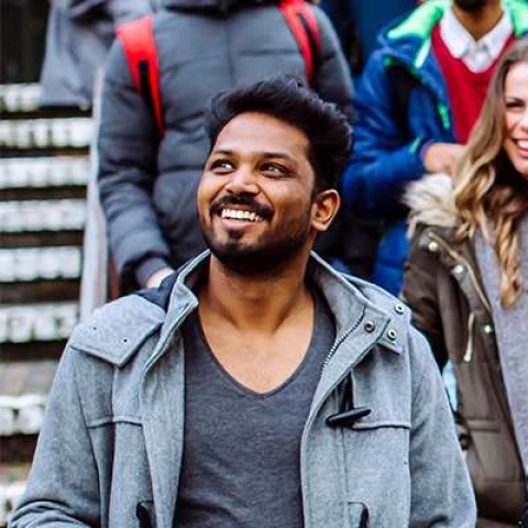 Two male international students walking down steps with others behind them
