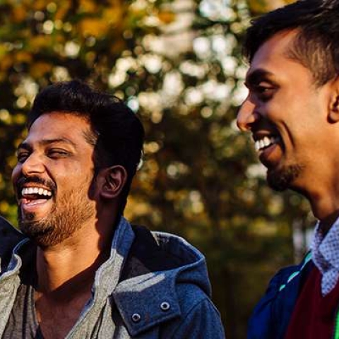 Four Indian students smiling and laughing while in conversation
