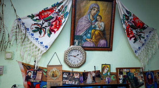 photo of a bedroom wall with some religious paintings and other trinkets