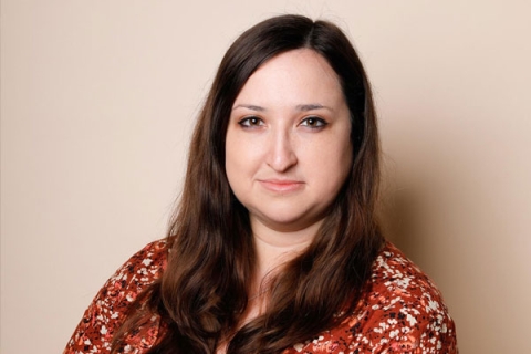 Headshot of Alice Hendy MBE smiling to camera wearing orange dress