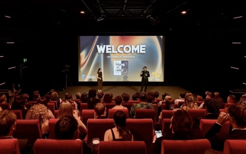 An audience in red chairs facing a screen showing a British Film Institute showcase